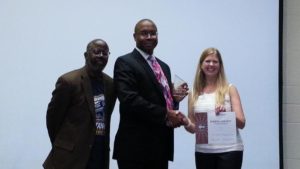 Kory May being presented Third Place by District Historian Reginald Williams and Division B Director Theresa Mickelson for the Humorous Speech Contest.